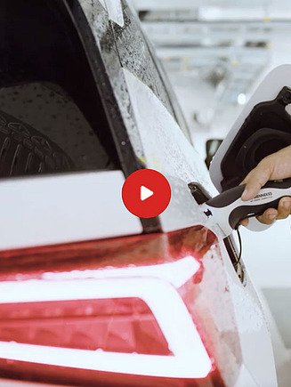 Preview image of a video: A person plugs a charging cable into an e-car