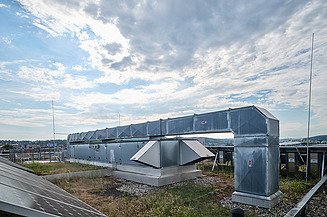 Gebäudetechnik Bild von einem Mann, der Gebäudetechnik durchführt und mit einer Zange an einem Rohr schraubt