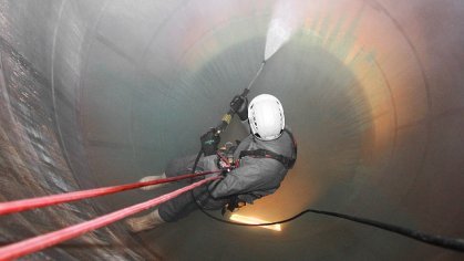 Bild eines Industriekletternden, der sich in einen Silo abseilt