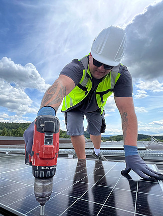 Picture of a man in protective clothing working on a photovoltaic system