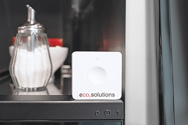  Picture of an eco2energy Smart Button standing next to a sugar dispenser on a coffee machine