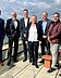 STRABAG PFS Kagerer-Gruppe Foto von sieben Menschen, die nebeneinander auf einem Dach stehen bei Sonnenscheinund in die Kamera lächeln