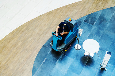 Picture of a floor cleaning with a ride-on machine