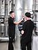 Picture of two men at a piece of equipment, carrying out checks using a measuring device and a laptop