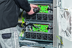 Photo of a service technician working on a control cabinet