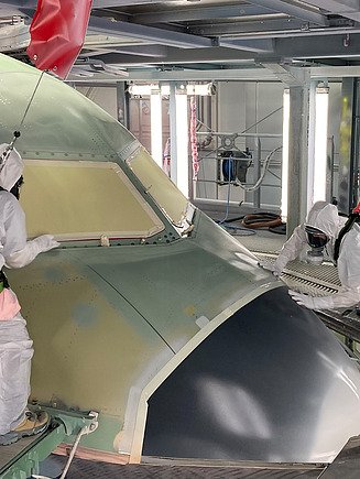 Obrázek dvou lidí leštících vnější část letadla