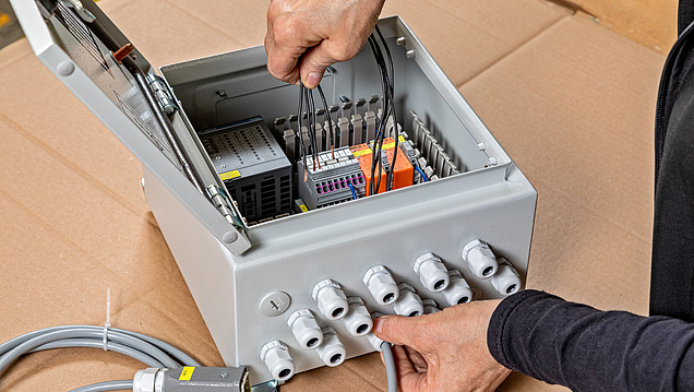 Obrázek 2 rukou provádějících elektrické práce na spínacím prvku