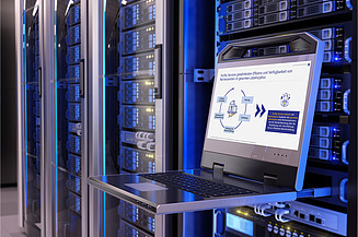 Ein Serverraum mit mehreren Serverschränken, die mit blauen Lichtern beleuchtet sind. Im Vordergrund steht ein ausziehbares Laptop-Tablett mit einem Laptop, auf dessen Bildschirm eine Präsentation zum Thema Facility Services und Rechenzentren zu sehen ist. 