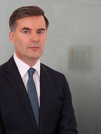 Foto von einem Mann in Anzug vor einer Glasscheibe