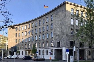 STRABAG PFS manages multiple locations for the Federal Agency for Public Safety Digital Radio (BDBOS), which is based in Berlin. Photo of a curved building with a German flag on its roof