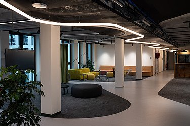 Moderní otevřená kancelář v průmyslovém designu se salonky, moderní zářivkové osvětlení.