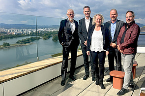 Foto vier Männern und einer Frau auf einer Dachterrasse