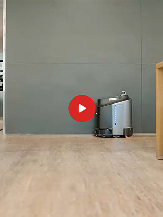 Preview image of a video: a cleaning robot stands between two wooden benches, next to a kitchen entrance