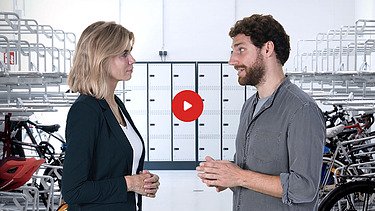 Vorschaubild Yotube Video: eine Frau und ein Mann stehen in einem Fahrradkeller und sich gegenüber