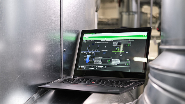 Foto von einem Laptop auf dem Rohr einer technischen Anlage 
