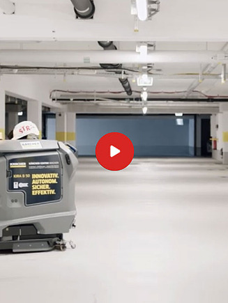 Preview image of a video: a cleaning robot stands in an illuminated underground parking garage