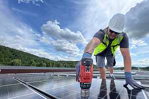 Picture of a man in protective clothing working on a photovoltaic system