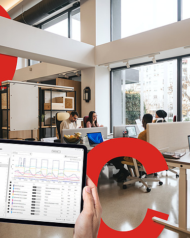 Obrázek kancelářského prostoru s udržitelným a digitálním provozem budovy s velkými červenými displeji C, O a 2. V popředí je vidět navigátor eco2state na tabletu.