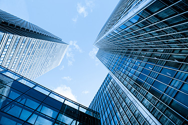 Hochhäuser aus Glas ragen in den blauen Himmel