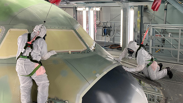 Picture of two people polishing the outside of an airplane