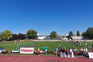 STRABAG PFS Football Cup 2024 Photo of a football pitch with players and spectators under a clear blue sky