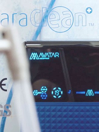 Obrázek zařízení na výrobu ozonizované vody, v popředí ruka držící hadici, ze které vytéká voda