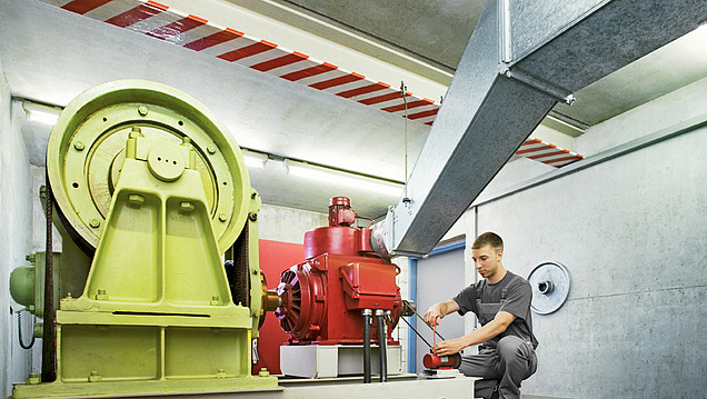 Ein Techniker arbeitet in einem Maschinenraum an einer großen Industrieanlage