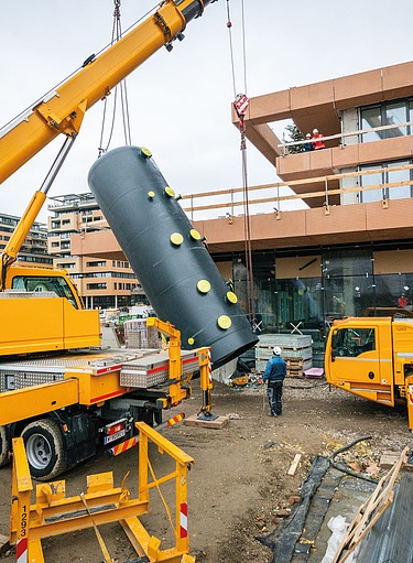 Ein Serverraum mit mehreren Serverschränken, die mit blauen Lichtern beleuchtet sind. Im Vordergrund steht ein ausziehbares Laptop-Tablett mit einem Laptop, auf dessen Bildschirm eine Präsentation zum Thema Facility Services und Rechenzentren zu sehen ist. 