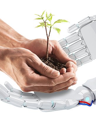 Obrázek dvou robotických rukou a dvou lidských rukou s půdou a rostliny rostoucí v nich