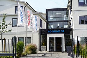 STRABAG PFS Bockholdt Foto von einem Gebaeudeeingang mit Aufschrift Bockholdt und drei Flaggen links