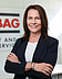 Photo of a woman in a business look in front of a wall on which STRABAG Property and Facility Services is written