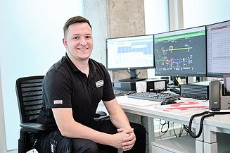 Objektmanagement STRABAG PFS Österreich Foto von einem Mitarbeiter am Schreibtisch mit drei Monitoren und Telefon