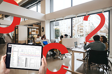 Picture of an office room with large red displays of C, O and 2. The eco2state navigator can be seen in the foreground on a tablet.