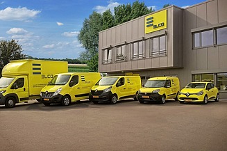 Photo of a fleet of yellow vehicles in front of a building
