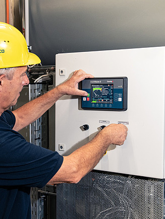 Photo of a man in a hard hat working on an installation