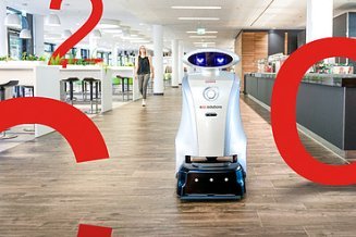 Foto von einem Reinigungsroboter auf einem langen Flur, daneben sind große rote Zeichen C, O, 2