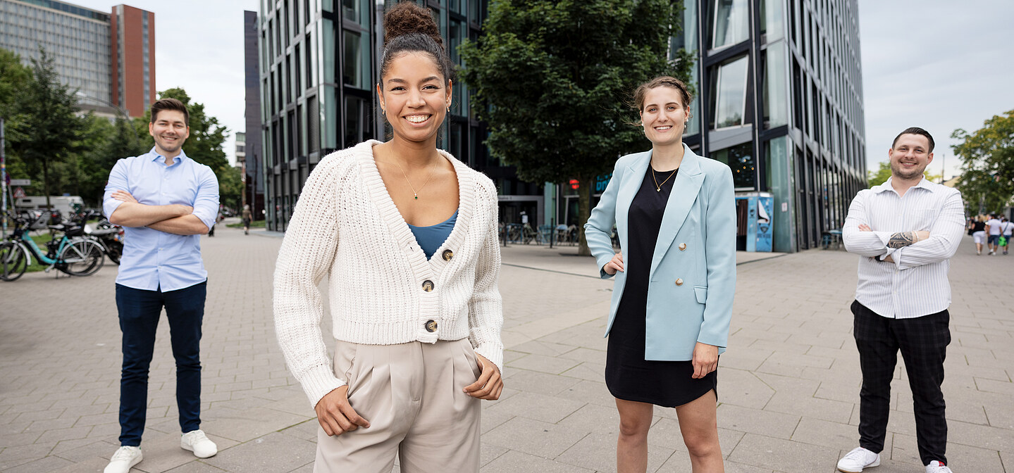 Zaměstnanci před vysokou kancelářskou budovou