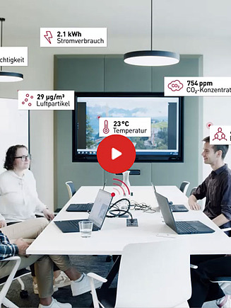 Preview image of a video: four employees sit in a meeting room, with room data floating around them, which is recorded using sensors.
