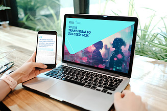 Studie auf Laptop ein Hand hält ein smartphone, auf dem ein Zitat sichtbar ist